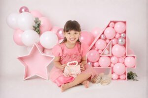 Girl celebrates fourth birthday with pink balloons
