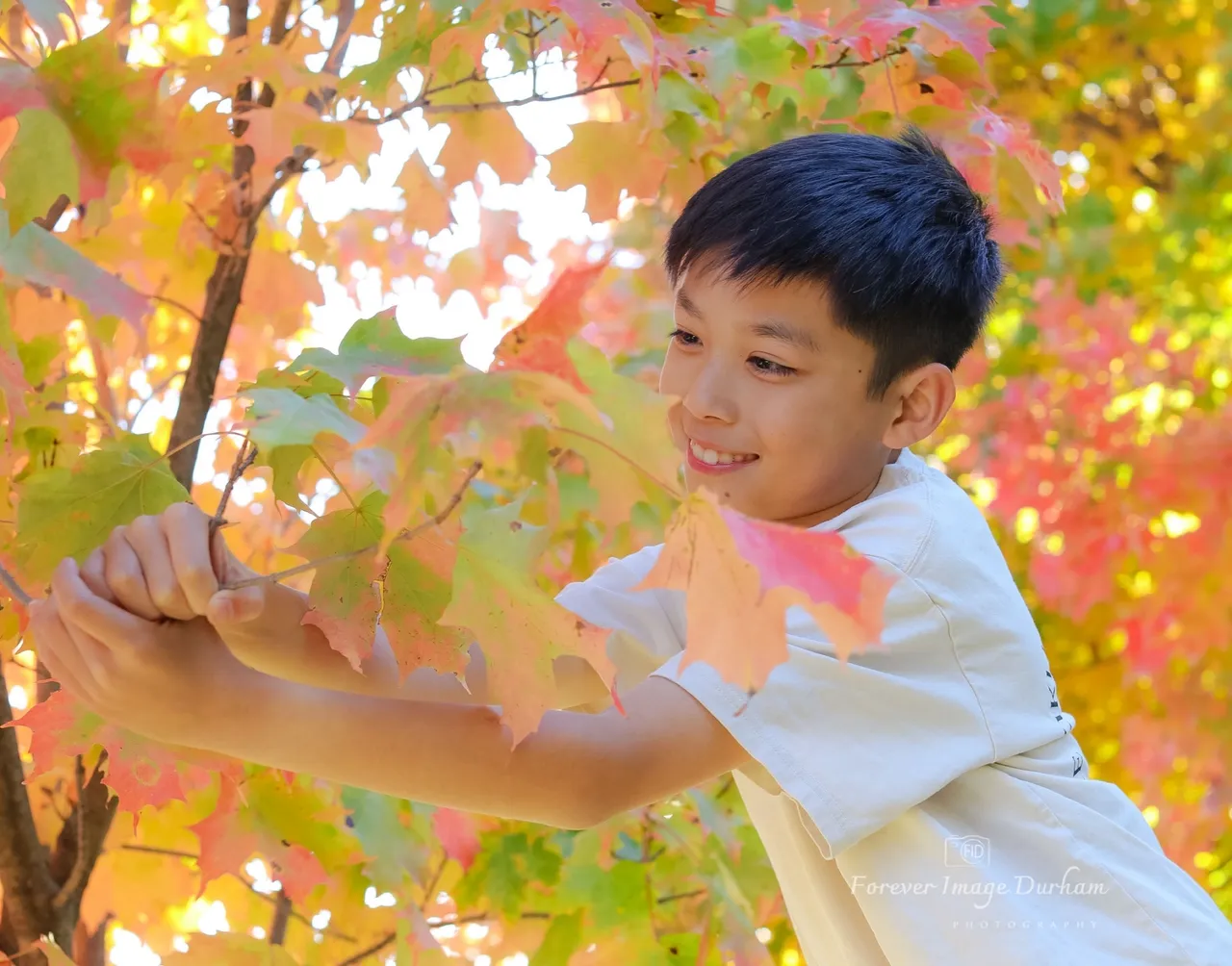Boy enjoying autumn leaves