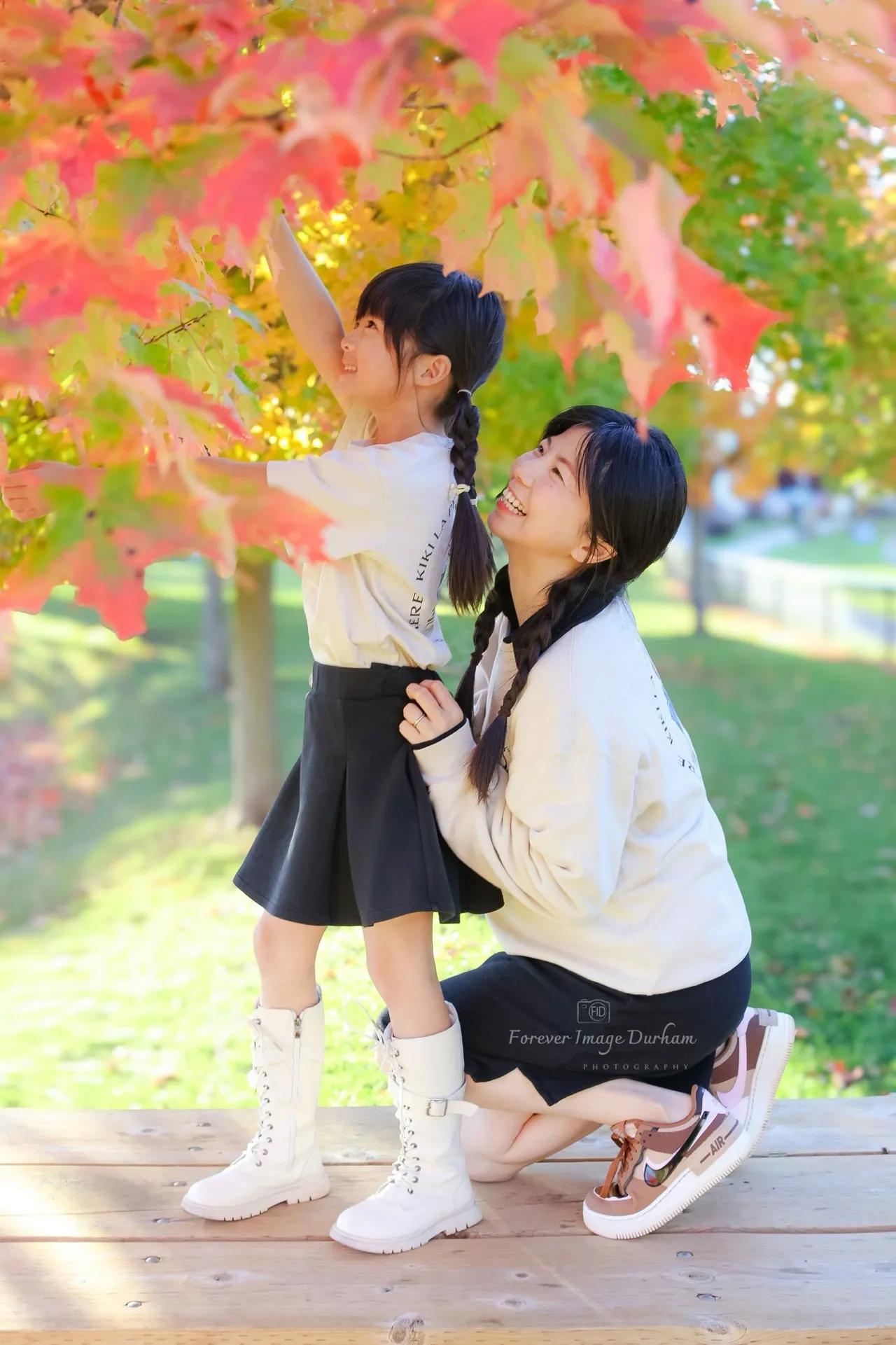 Mother and daughter under fall foliage