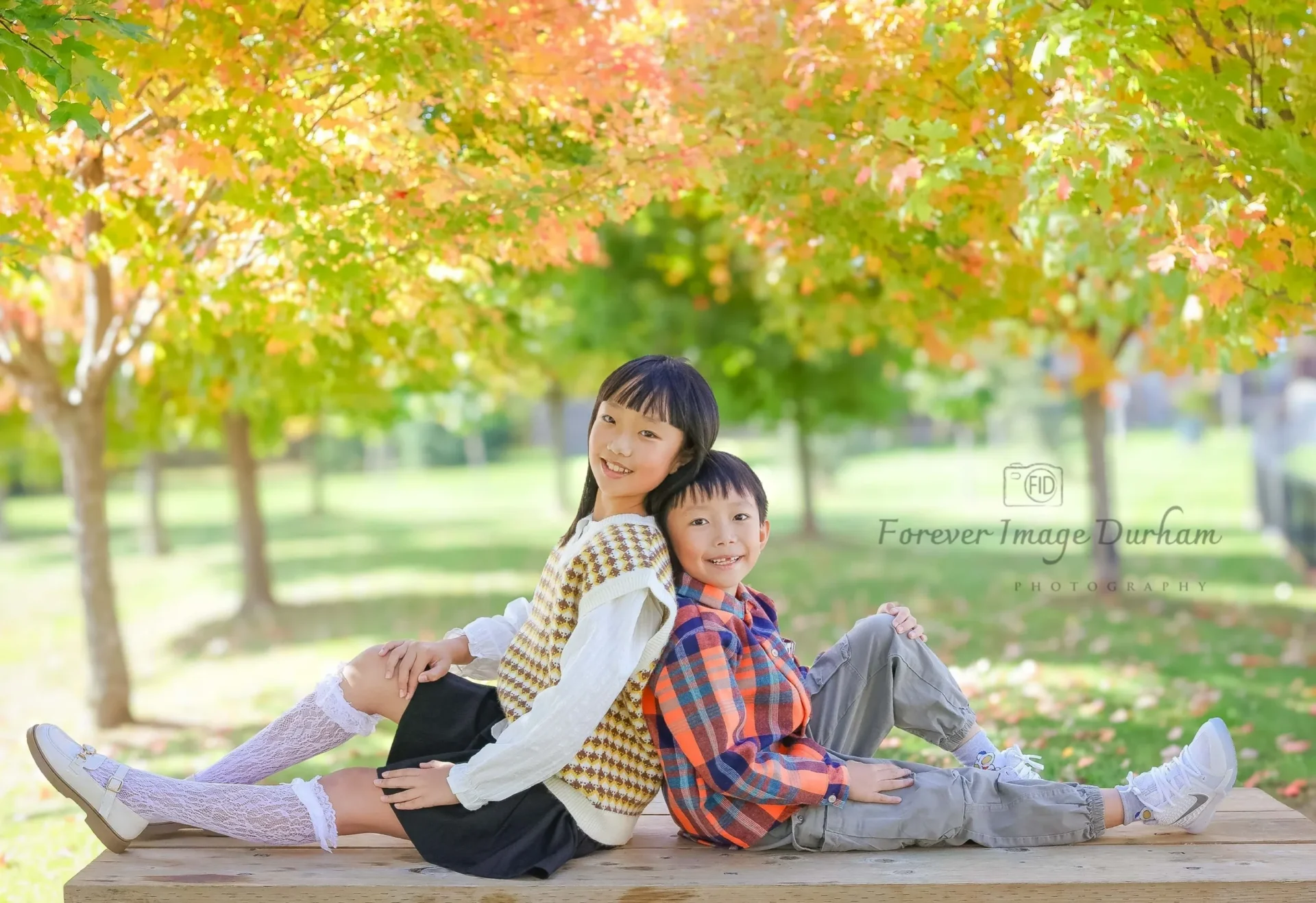 Children smiling under autumn trees