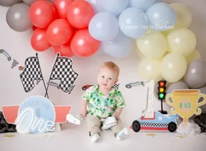 Baby with race-themed birthday decorations