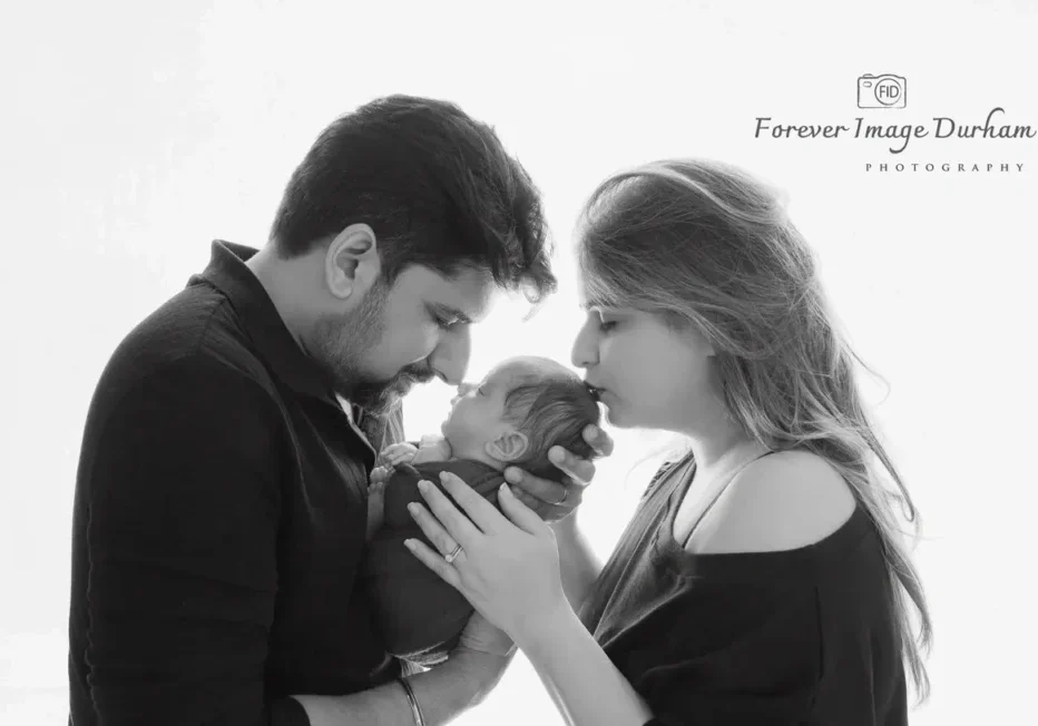 Parents affectionately holding newborn baby